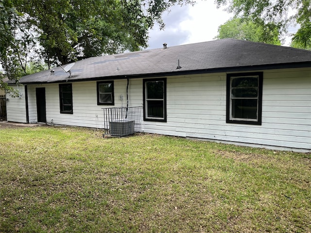 rear view of property with a yard and central AC unit