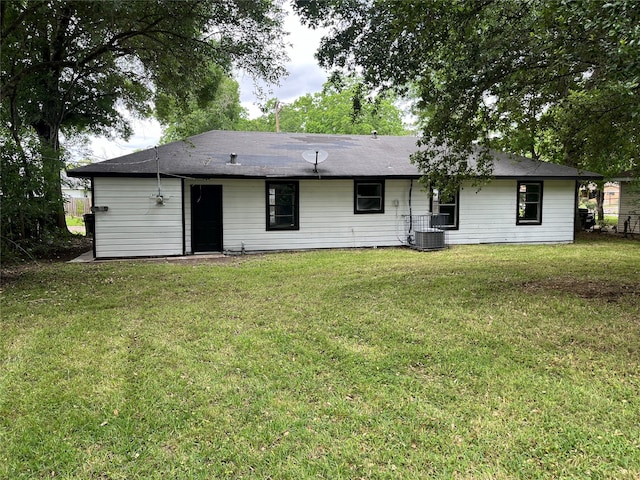 back of house featuring a lawn and central air condition unit