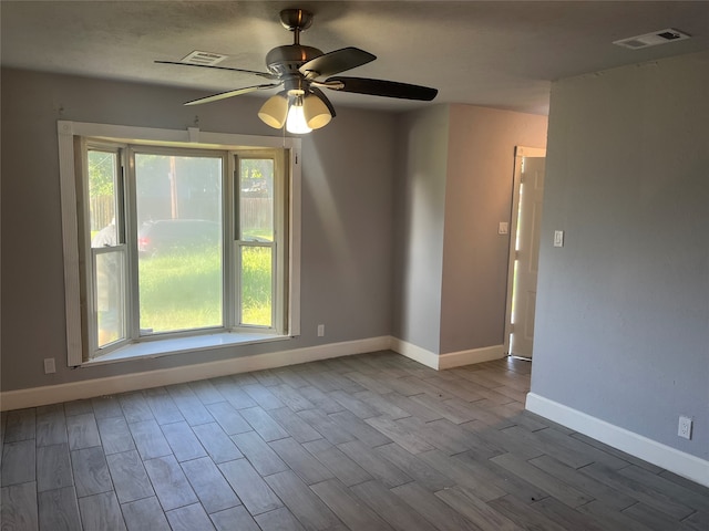 empty room with hardwood / wood-style flooring, plenty of natural light, and ceiling fan