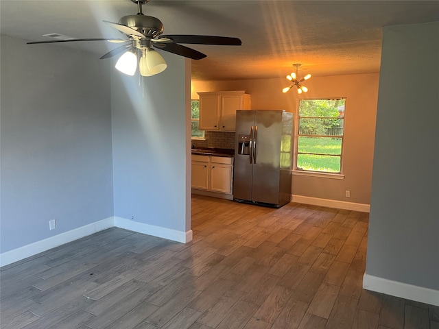 kitchen with ceiling fan with notable chandelier, tasteful backsplash, hardwood / wood-style flooring, and stainless steel fridge with ice dispenser