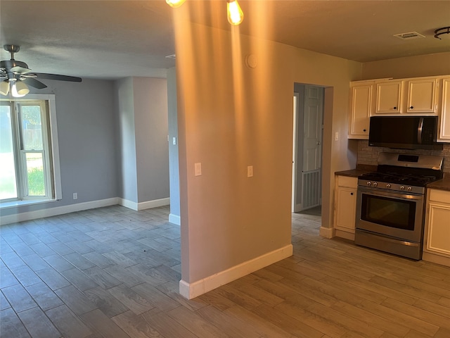 kitchen with ceiling fan, tasteful backsplash, stainless steel appliances, and light hardwood / wood-style floors