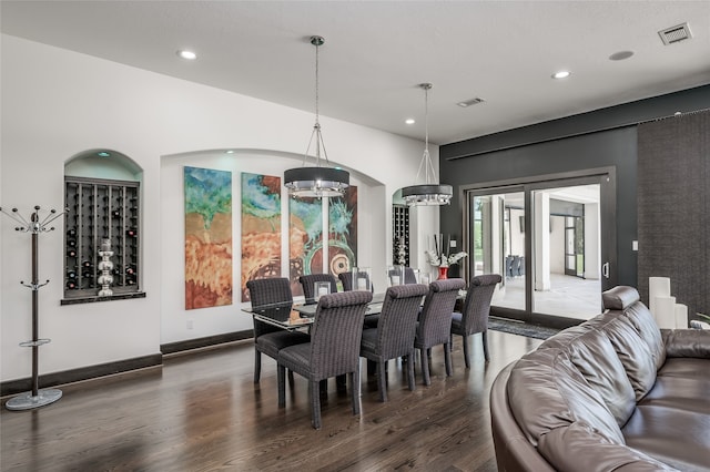 dining area with dark hardwood / wood-style floors and a chandelier