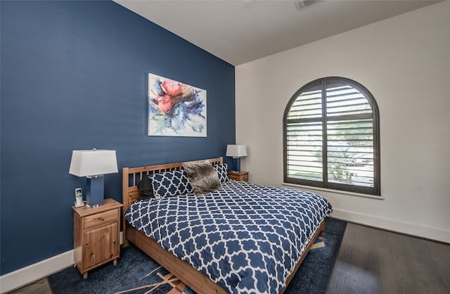 bedroom with dark hardwood / wood-style flooring