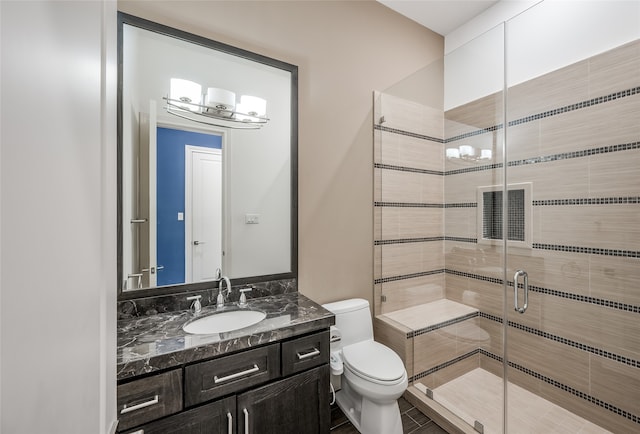 bathroom with large vanity, a shower with shower door, toilet, and tile flooring