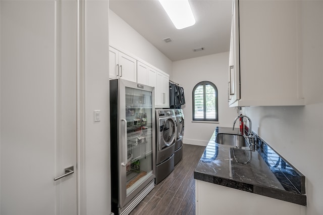 kitchen featuring white cabinets, range, washer and dryer, dark hardwood / wood-style floors, and sink