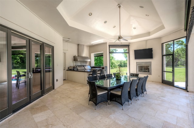 tiled dining room featuring a raised ceiling, ceiling fan, and french doors