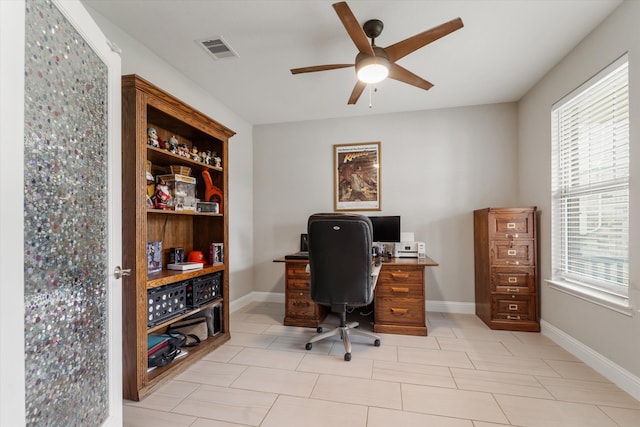 tiled home office featuring ceiling fan