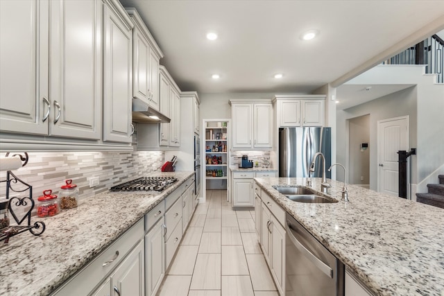 kitchen with backsplash, appliances with stainless steel finishes, sink, and white cabinets