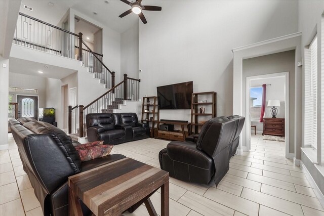 living room featuring ceiling fan, a high ceiling, a wealth of natural light, and light tile patterned floors