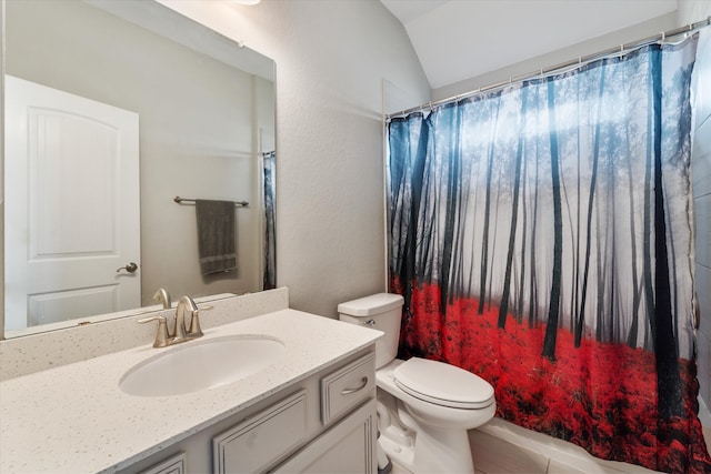 bathroom with vanity, toilet, tile patterned floors, and vaulted ceiling