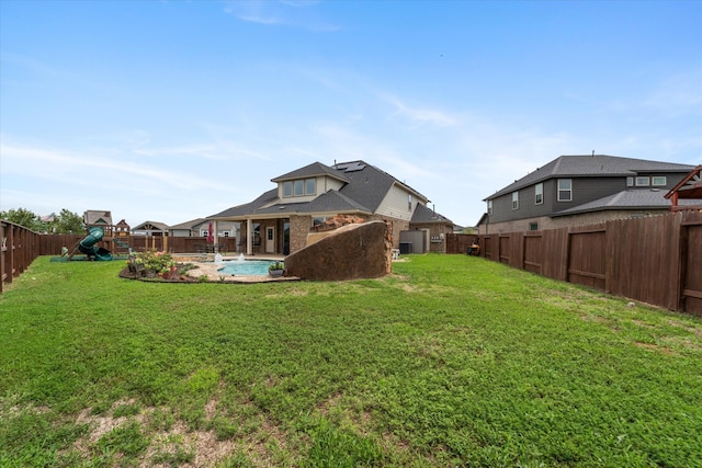 rear view of property with a patio area, a lawn, a fenced in pool, and a playground