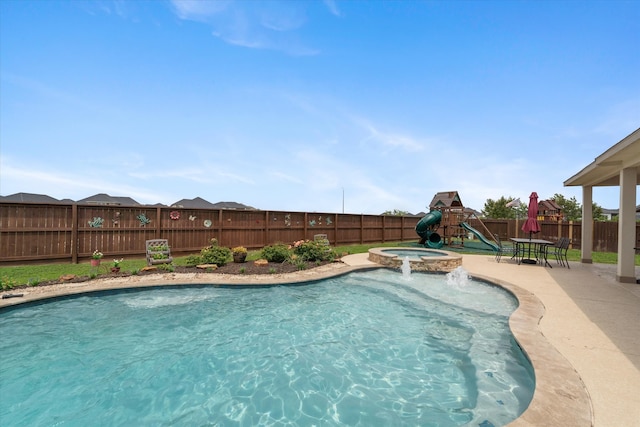 view of swimming pool featuring an in ground hot tub and a playground