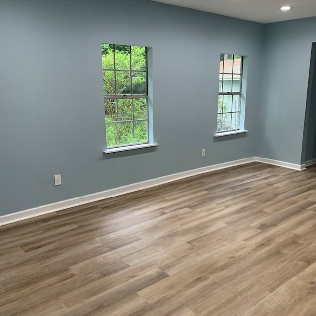 unfurnished room with a healthy amount of sunlight and hardwood / wood-style flooring