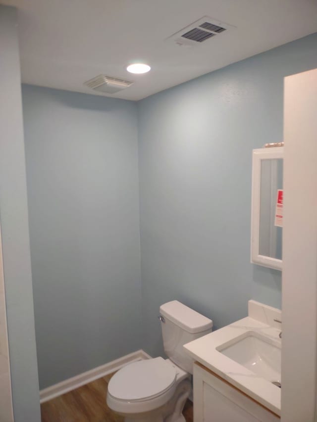 bathroom featuring hardwood / wood-style flooring, vanity, and toilet