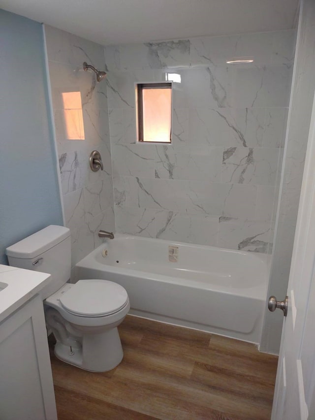 full bathroom with vanity, toilet, hardwood / wood-style flooring, and tiled shower / bath