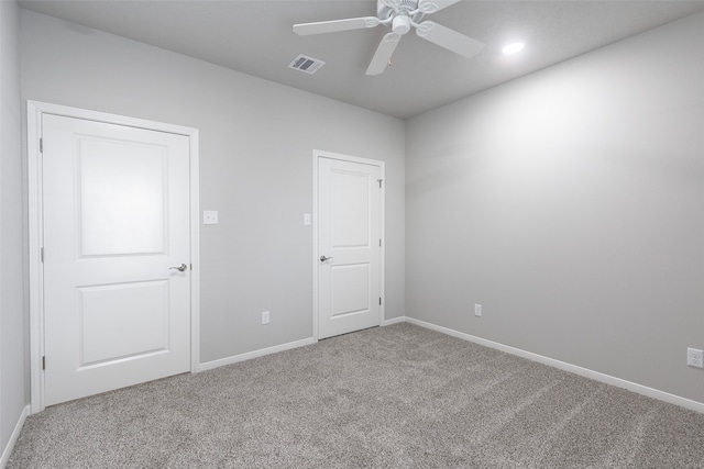 carpeted spare room with ceiling fan