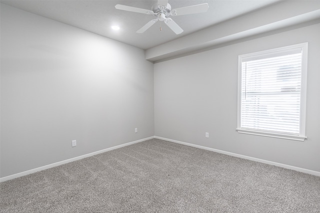 unfurnished room with ceiling fan and carpet