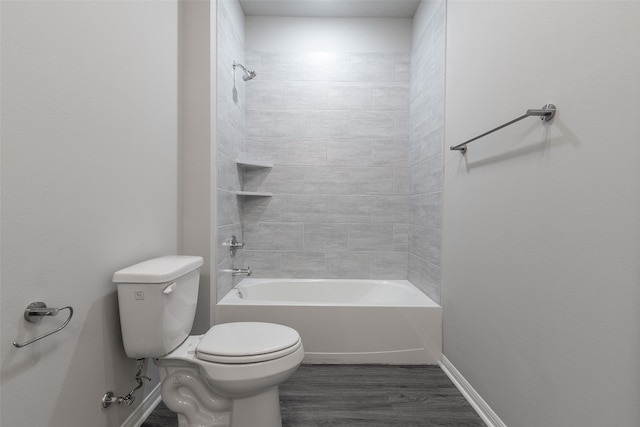 bathroom with wood-type flooring, tiled shower / bath combo, and toilet