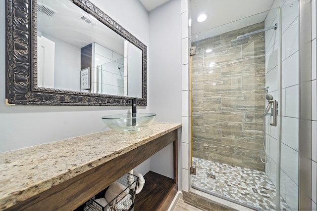 bathroom featuring sink, an enclosed shower, and hardwood / wood-style flooring