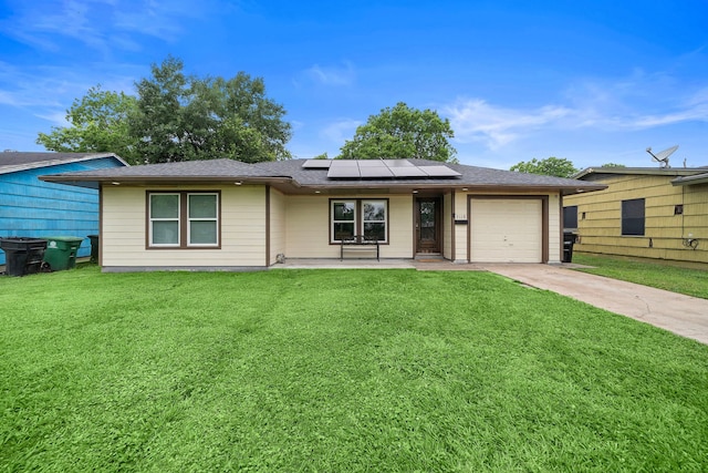 ranch-style home featuring covered porch, a garage, a front yard, and solar panels