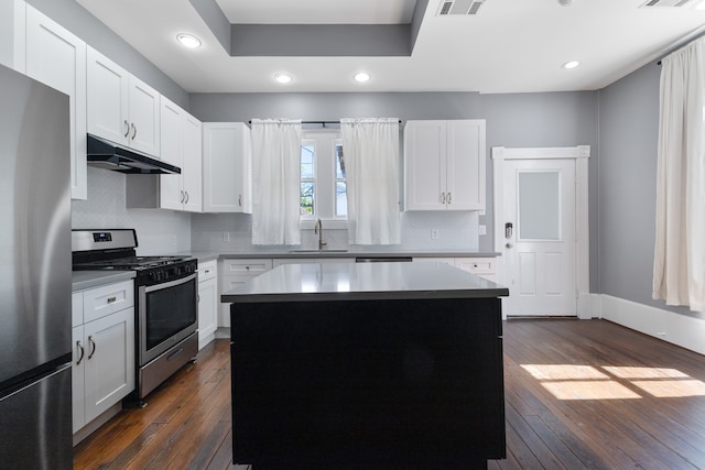 kitchen featuring a kitchen island, appliances with stainless steel finishes, dark hardwood / wood-style flooring, and white cabinetry