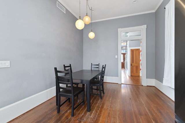 dining room featuring ornamental molding and dark hardwood / wood-style flooring