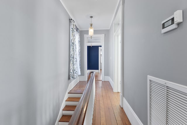 hallway with hardwood / wood-style floors and ornamental molding