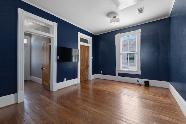 empty room featuring ornamental molding and wood-type flooring