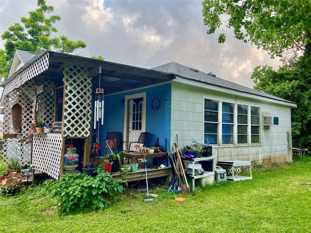 rear view of property featuring a lawn