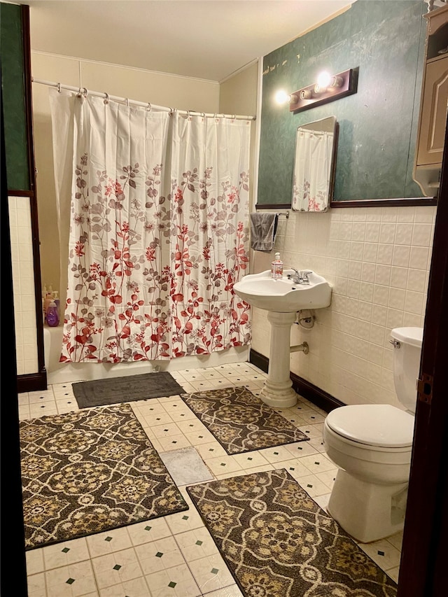 bathroom featuring shower / tub combo, toilet, tile flooring, and tile walls