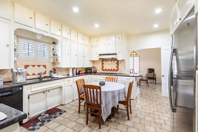 kitchen featuring appliances with stainless steel finishes, backsplash, light tile floors, and a wealth of natural light