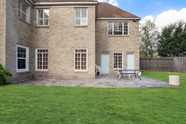 rear view of house featuring a patio area and a lawn