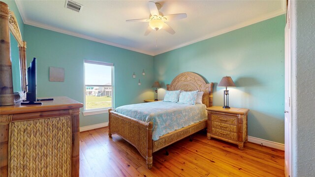 bedroom with ceiling fan, crown molding, and hardwood / wood-style flooring