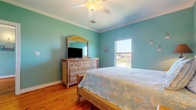 bedroom featuring hardwood / wood-style floors, ceiling fan, and crown molding