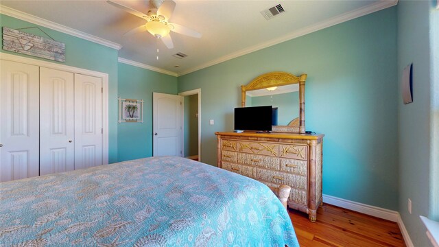 bedroom with ornamental molding, a closet, ceiling fan, and hardwood / wood-style flooring