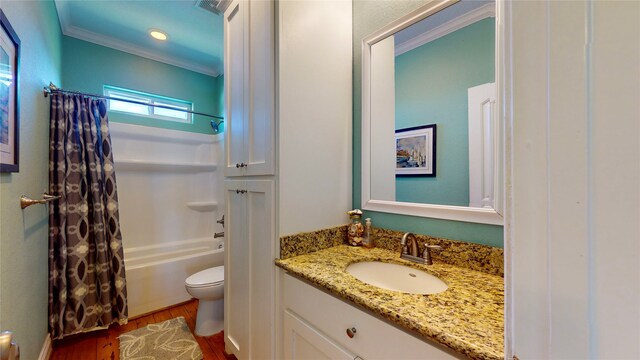 full bathroom featuring shower / bath combo with shower curtain, vanity, hardwood / wood-style floors, ornamental molding, and toilet