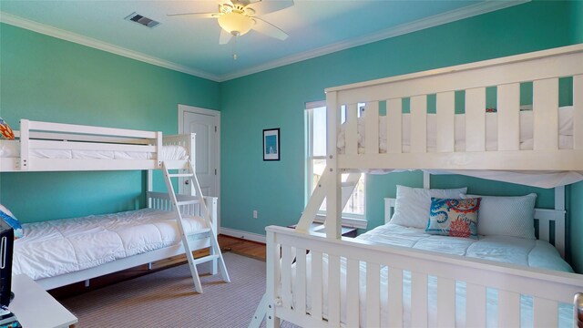 bedroom featuring wood-type flooring, ceiling fan, and crown molding