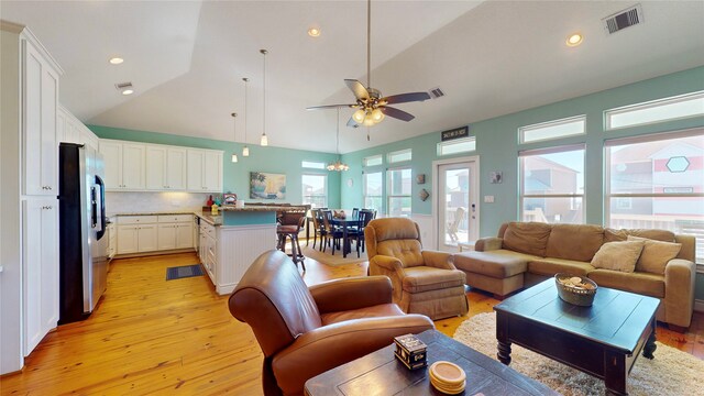 living room with high vaulted ceiling, light hardwood / wood-style floors, and ceiling fan