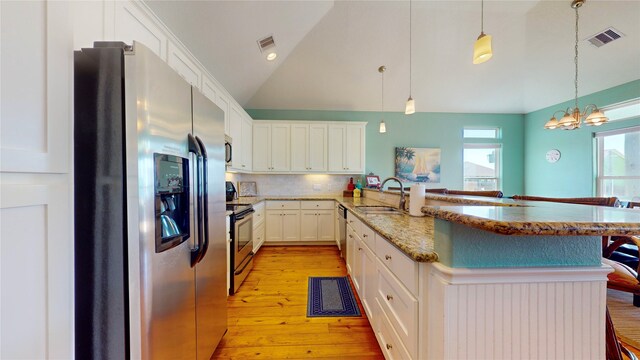 kitchen featuring sink, lofted ceiling, stainless steel appliances, light hardwood / wood-style flooring, and kitchen peninsula