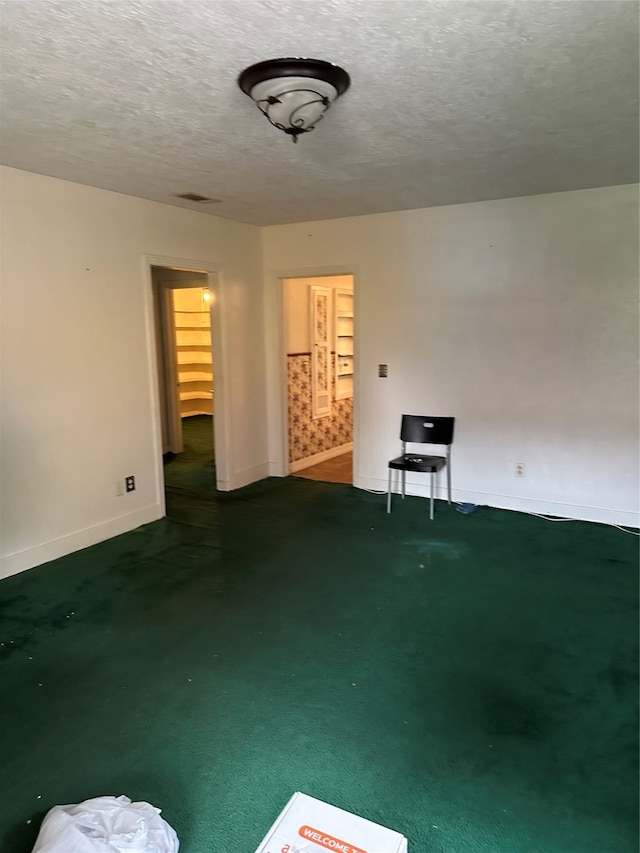 unfurnished room featuring a textured ceiling and carpet floors