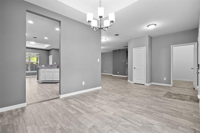 unfurnished dining area with light wood-type flooring and an inviting chandelier