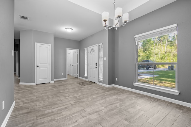 entrance foyer with an inviting chandelier and light wood-type flooring