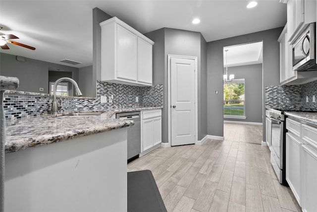 kitchen featuring light stone counters, sink, white cabinets, and appliances with stainless steel finishes