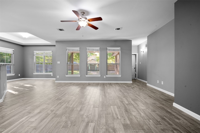 unfurnished living room featuring ceiling fan, a skylight, and hardwood / wood-style flooring