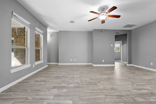 empty room with ceiling fan and light hardwood / wood-style floors