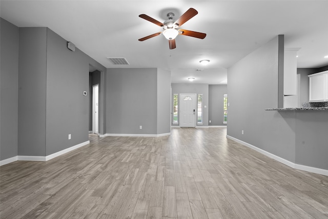 unfurnished living room featuring ceiling fan and light wood-type flooring