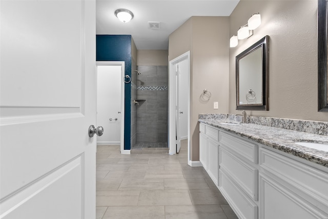 bathroom with vanity and a tile shower