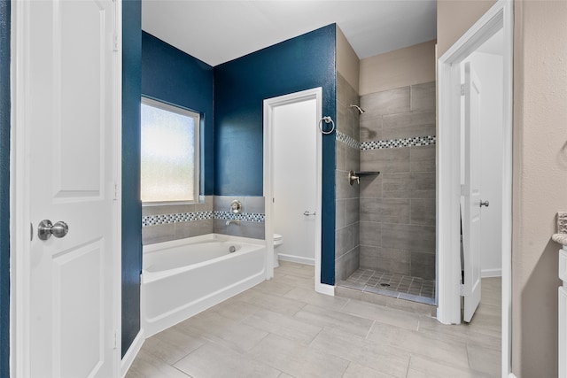 bathroom featuring toilet, tile patterned flooring, and separate shower and tub