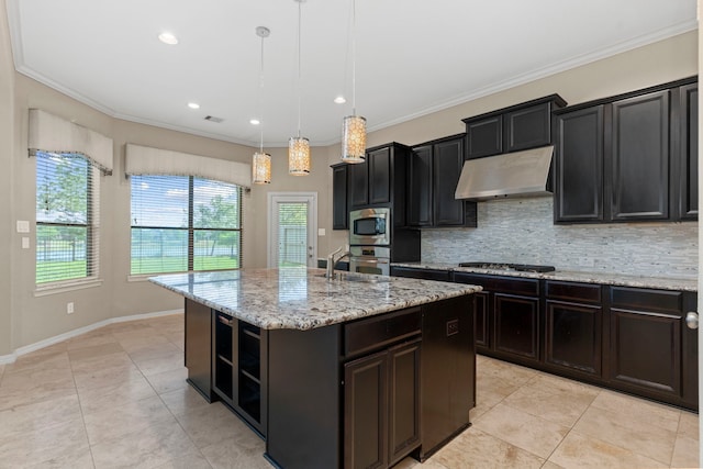 kitchen featuring stainless steel appliances, tasteful backsplash, an island with sink, pendant lighting, and light tile floors