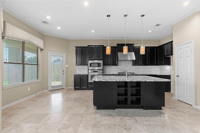 kitchen featuring decorative light fixtures, appliances with stainless steel finishes, a center island with sink, tasteful backsplash, and light tile floors